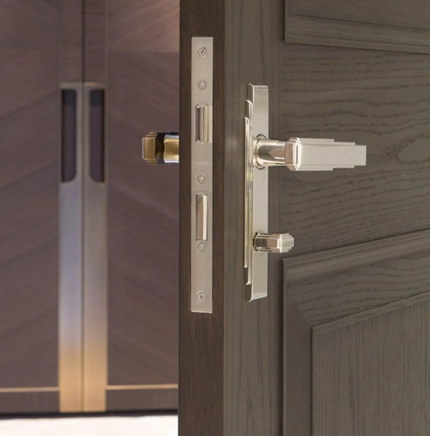 Open brown door with close up of silver door handle and hinge