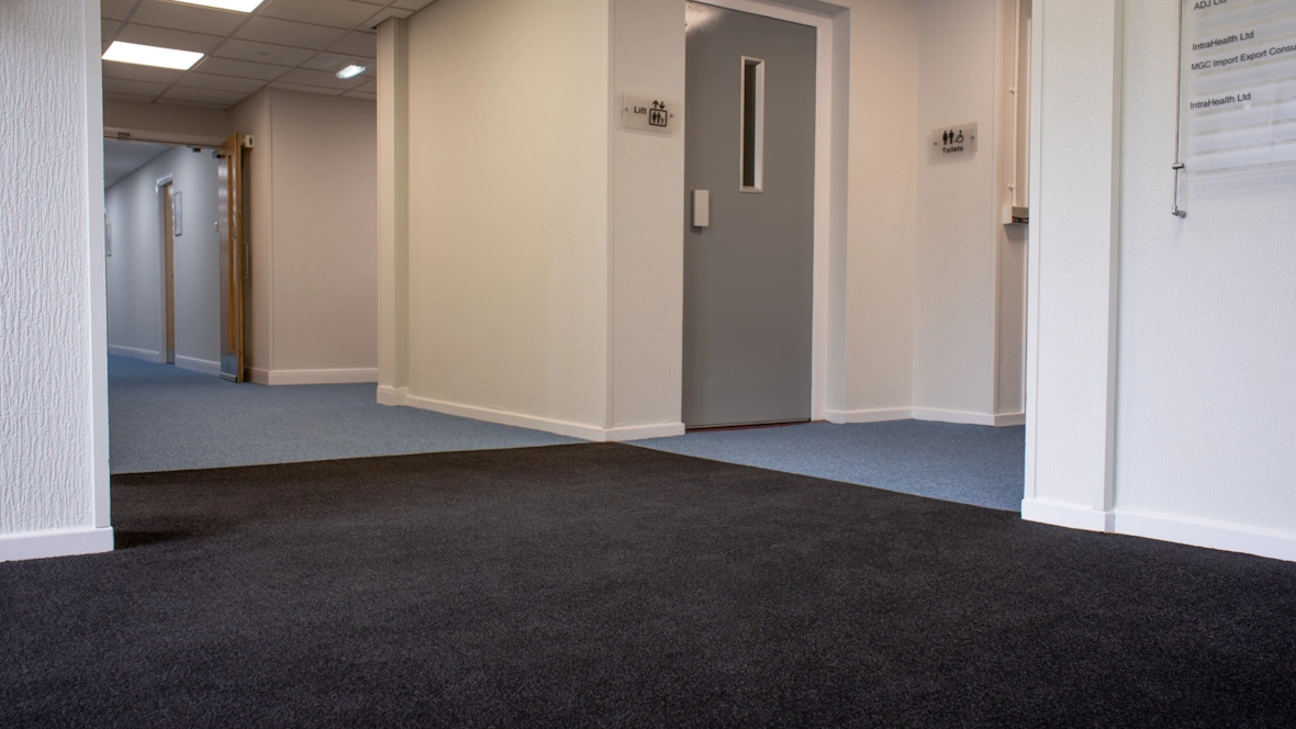 Office with blue carpet and staircase