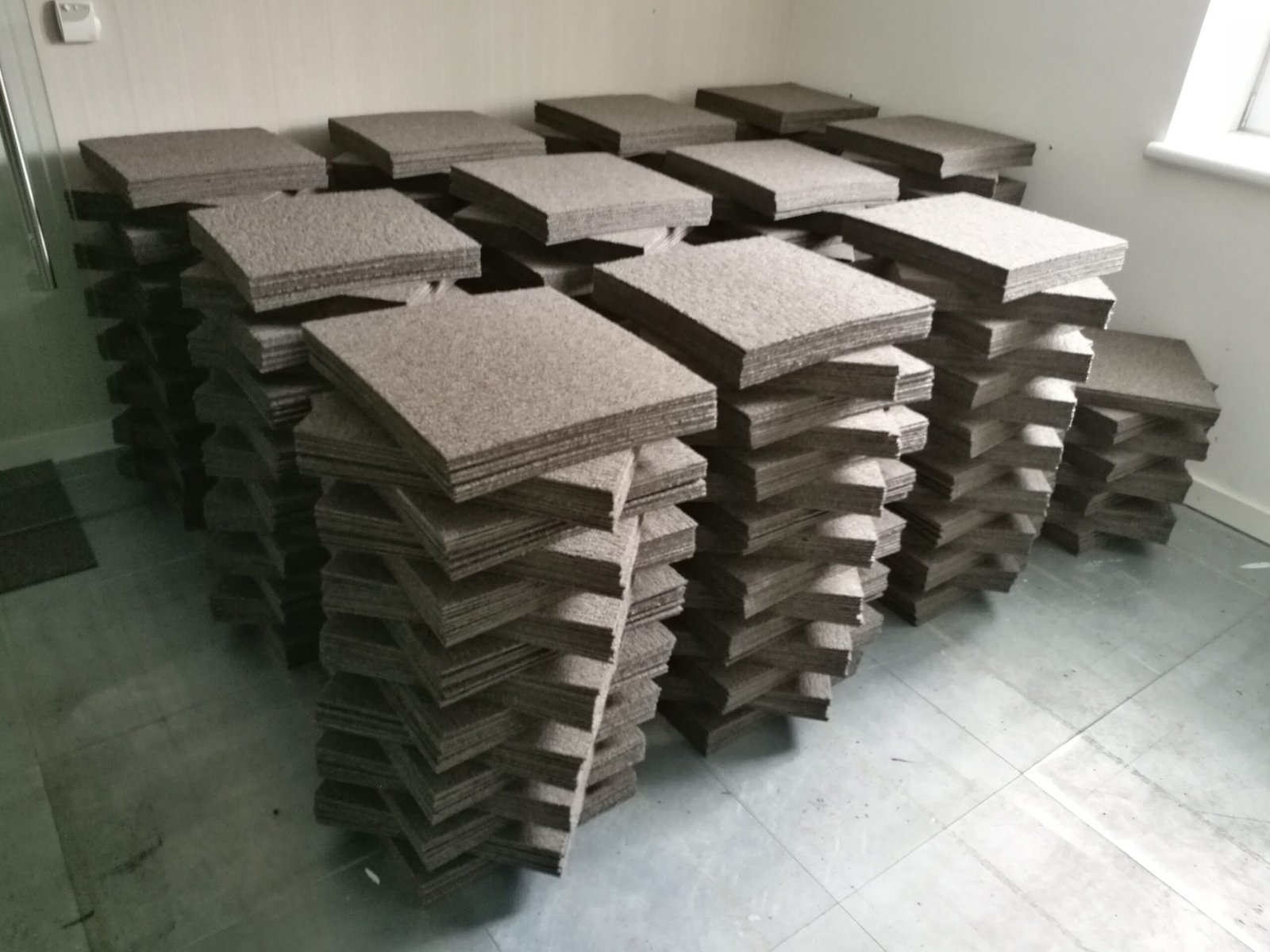 Stack of grey carpet tiles to be reused - Envirocycle London